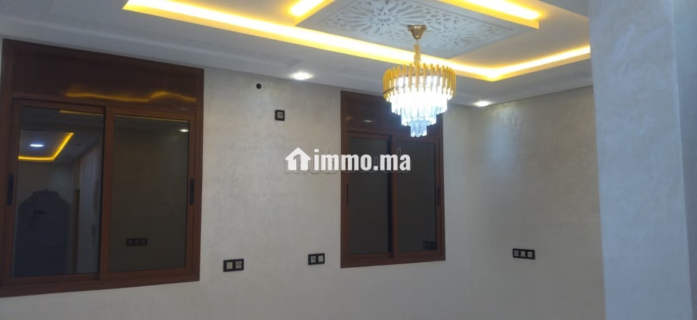 Appartement à louer à Ben Guerir.
Superficie 100 m².
Salon traditionnel et porte blindée - Location Immobilier - Ben guerir - photo 1